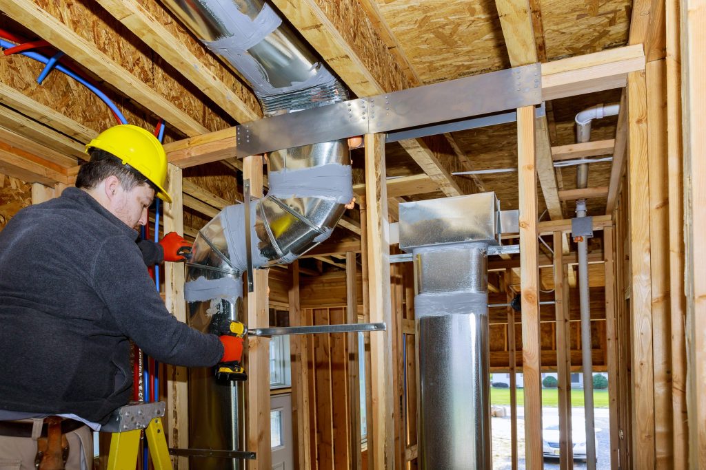 worker fixing ductwork
